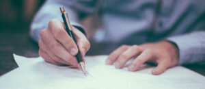 mężczyzna podpisuje dokument na zakup paneli fotowoltaicznych w Tranowie