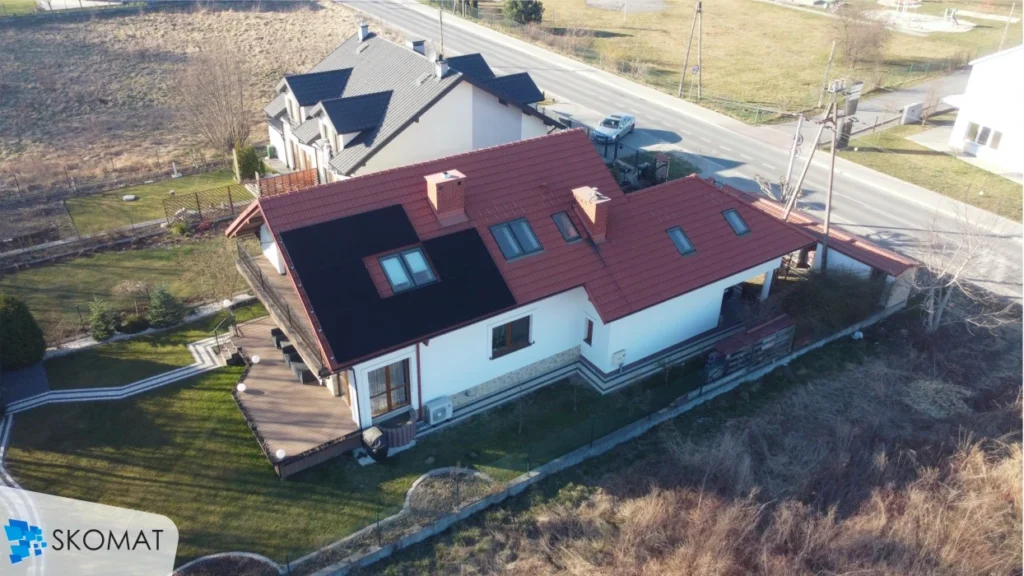 fotowoltaika na dachu domu z czerwonym dachem